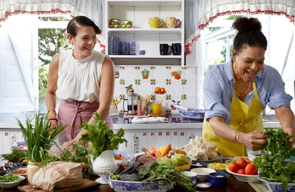 sisters Michelle and Suzanne Rousseau in the kitchen with a table of ingredients