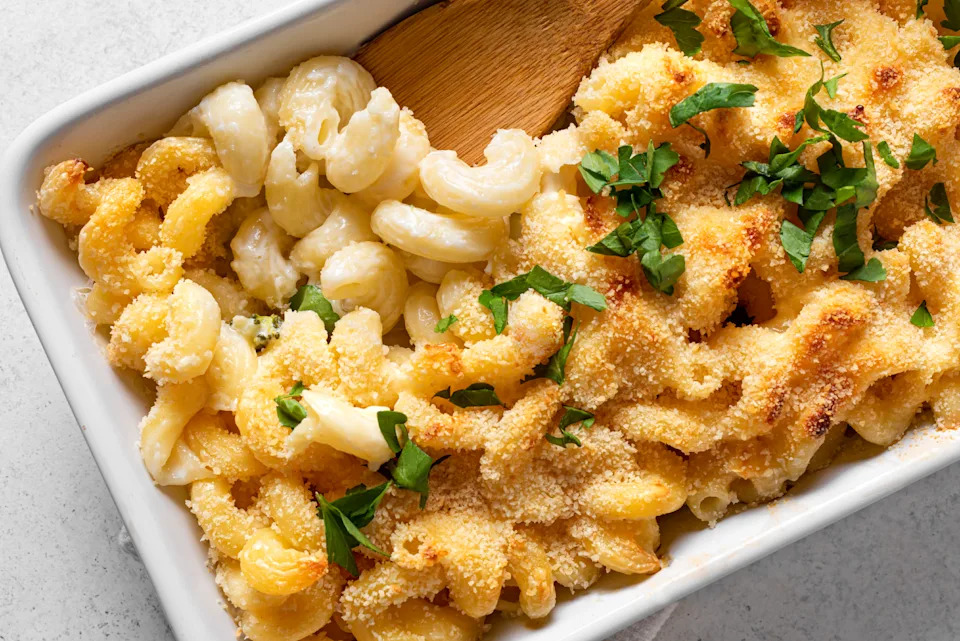 Mac and cheese with breadcrumbs oven baked close up. Traditional american meal, creamy macaroni pasta and cheese sauce casserole.