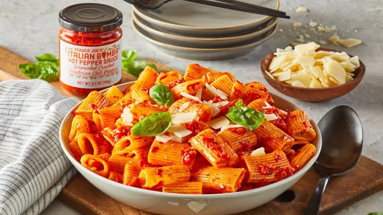 Trader Joe's Italian Bomba hot pepper sauce mixed with pasta in a white bowl and topped with cheese