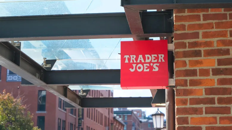Trader Joe's sign on the exterior of a brick building with a glass awning