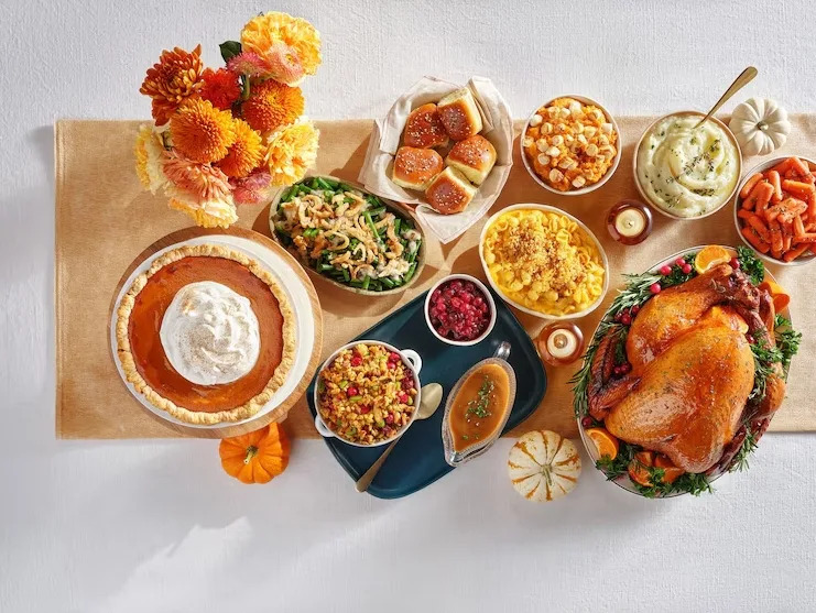Overhead view of Aldi’s Thanksgiving meal including turkey, sides, and pumpkin pie arranged on a holiday table.