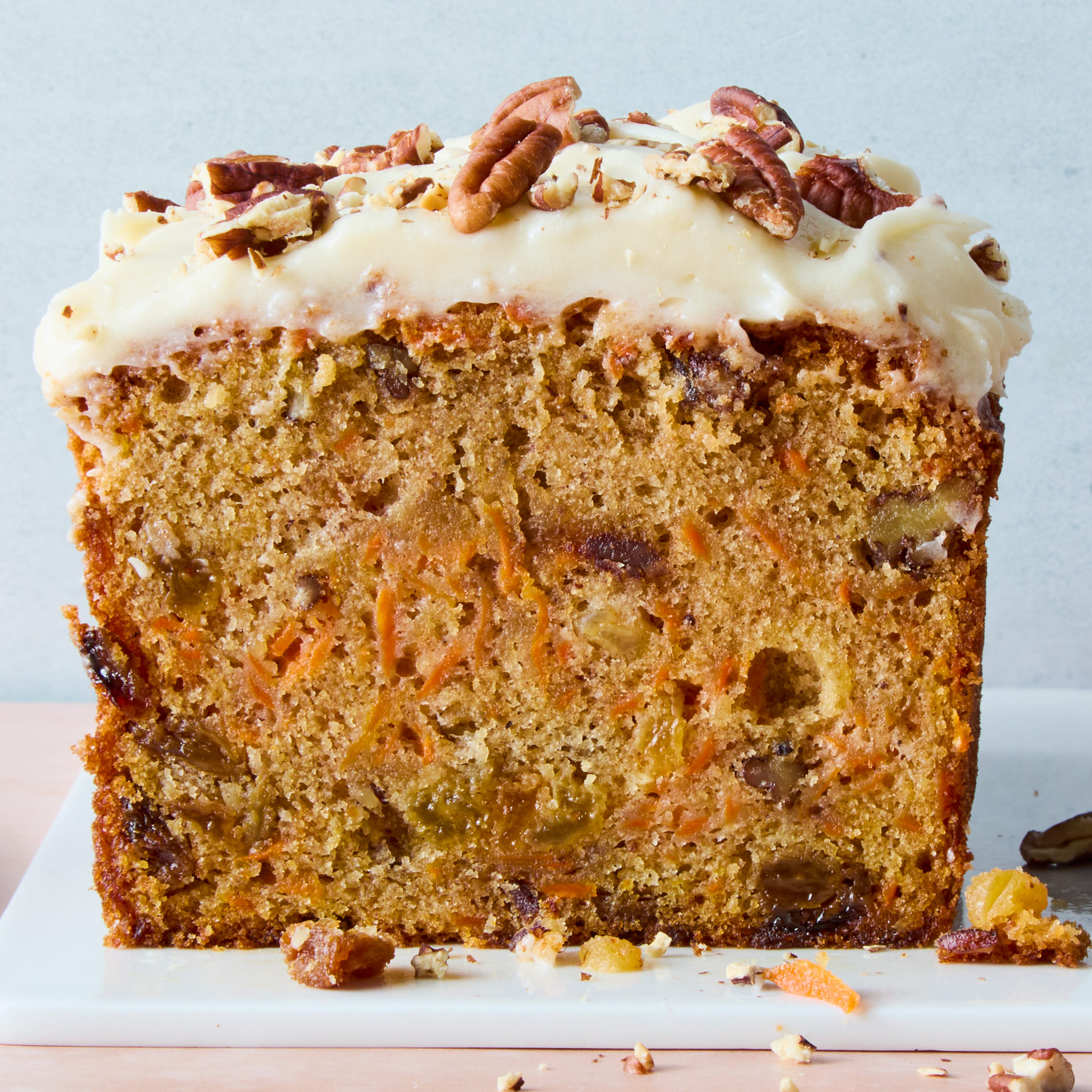 carrot cake loaf with cream cheese frosting and chopped nuts