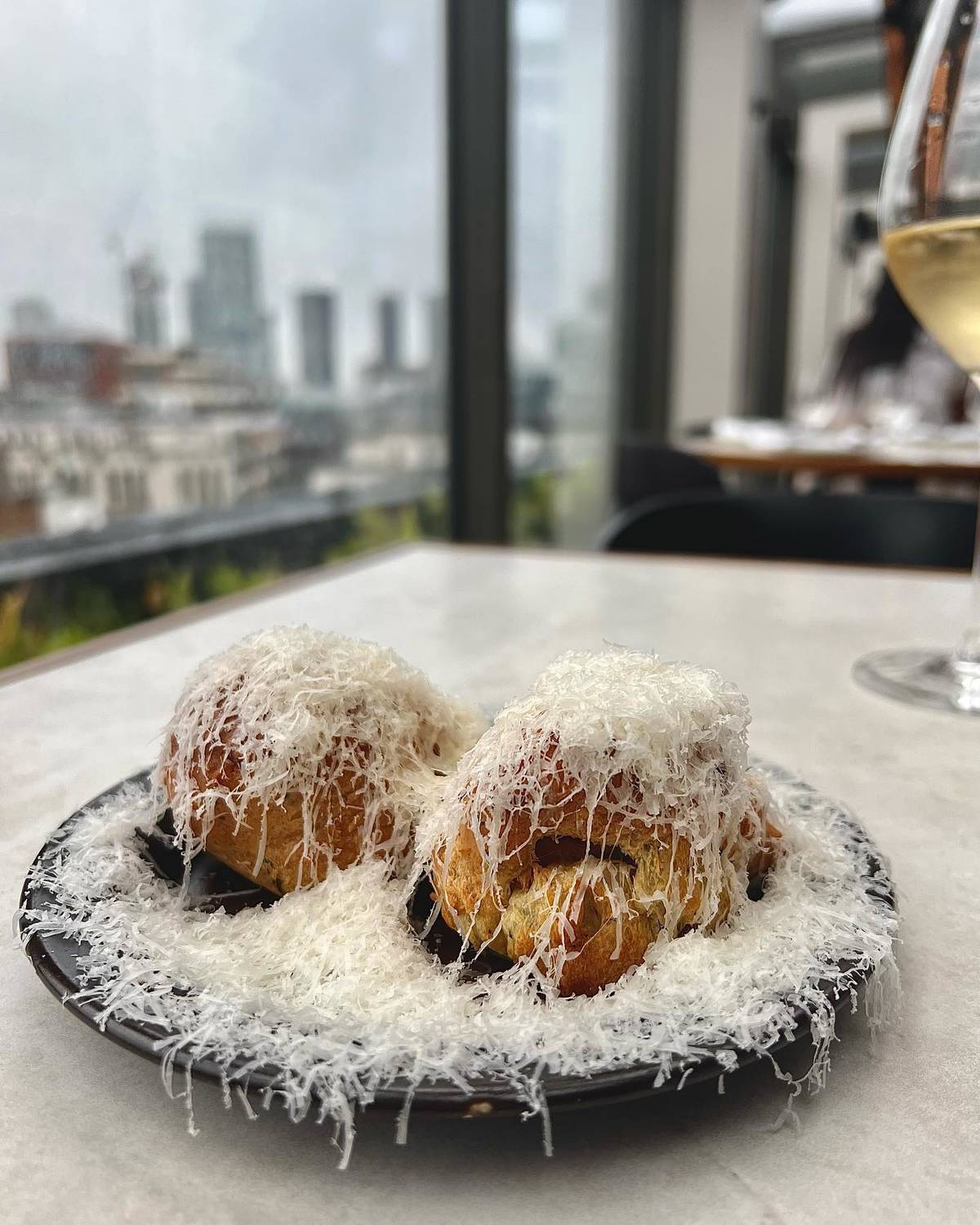 gougeres with grated cheese over top on table at Climat restaurant in Manchester