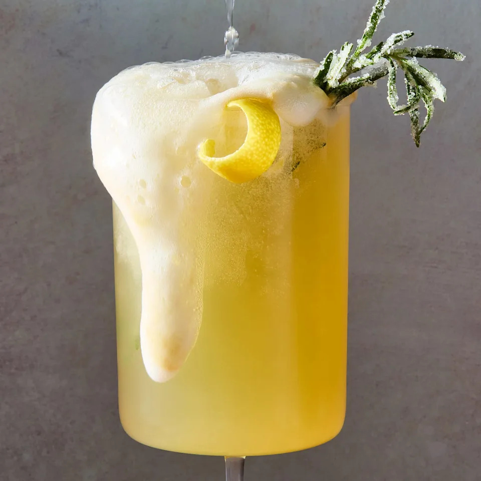 bee's knees mocktail spritz with a lemon twist and sugared rosemary