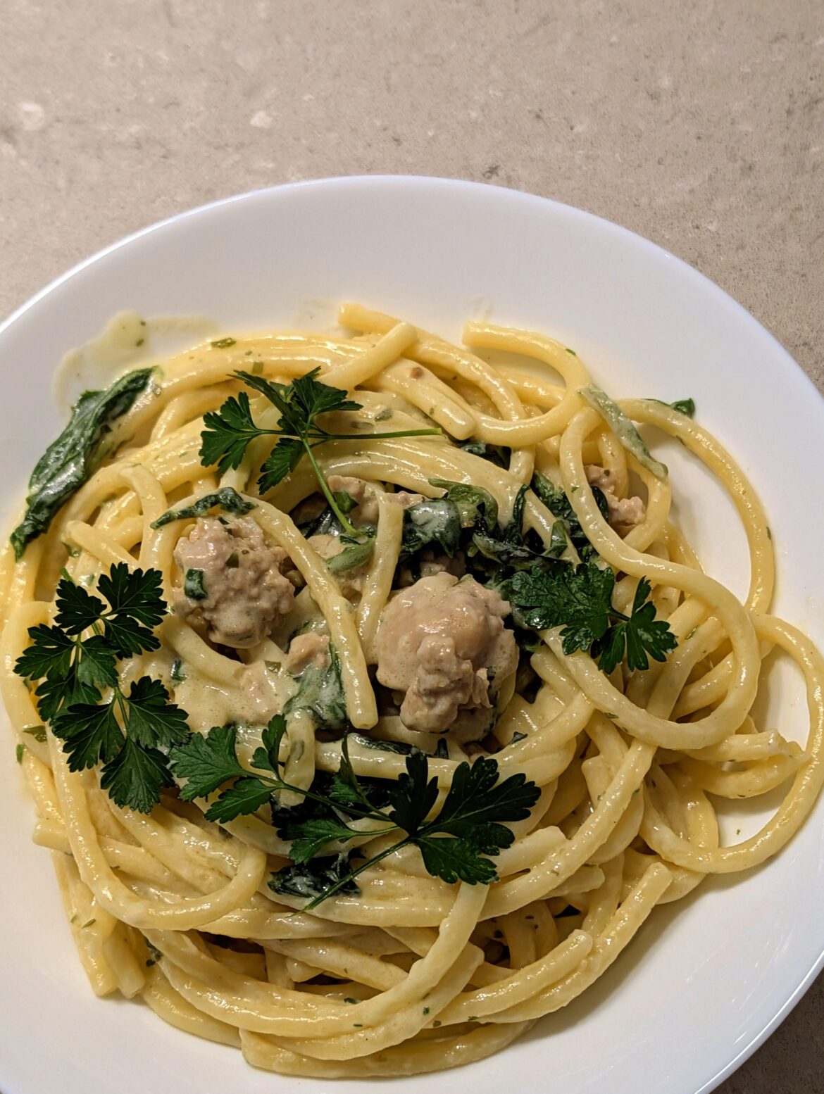 Creamy Boursain Buccatini with sausage garnished with fresh parsley