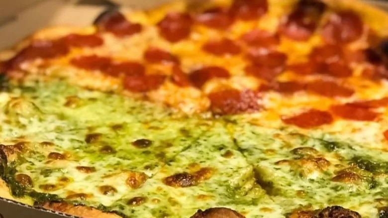 Close-up of a half pesto, half pepperoni pizza from Dani's House of Pizza