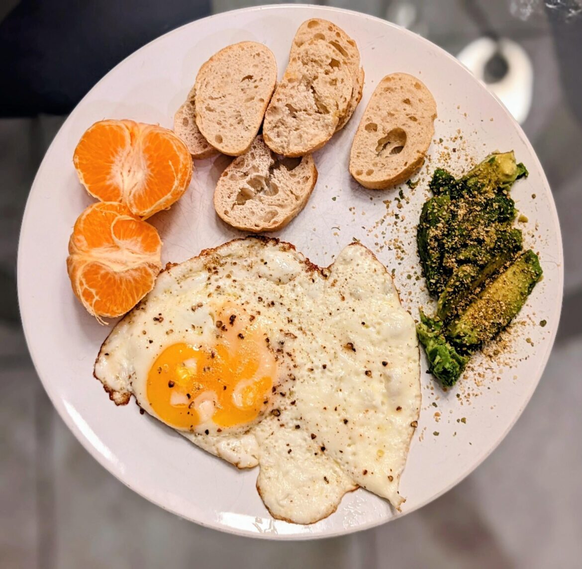 Fried egg with avocado mash and mandarin orange