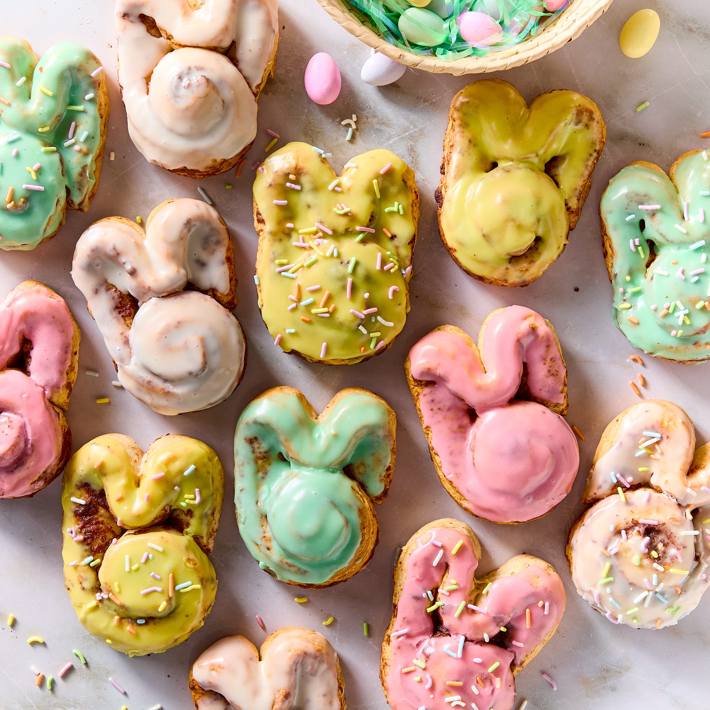 cinnamon rolls shaped like a bunny iced with colored icing and topped with sprinkles