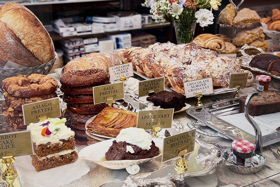A bakery counter covered with French-style pastries and bread.