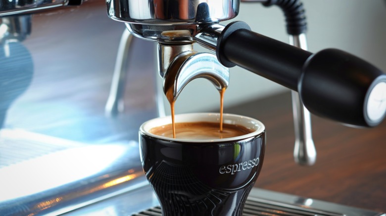 Freshly brewed cup of espresso being made by an espresso machine