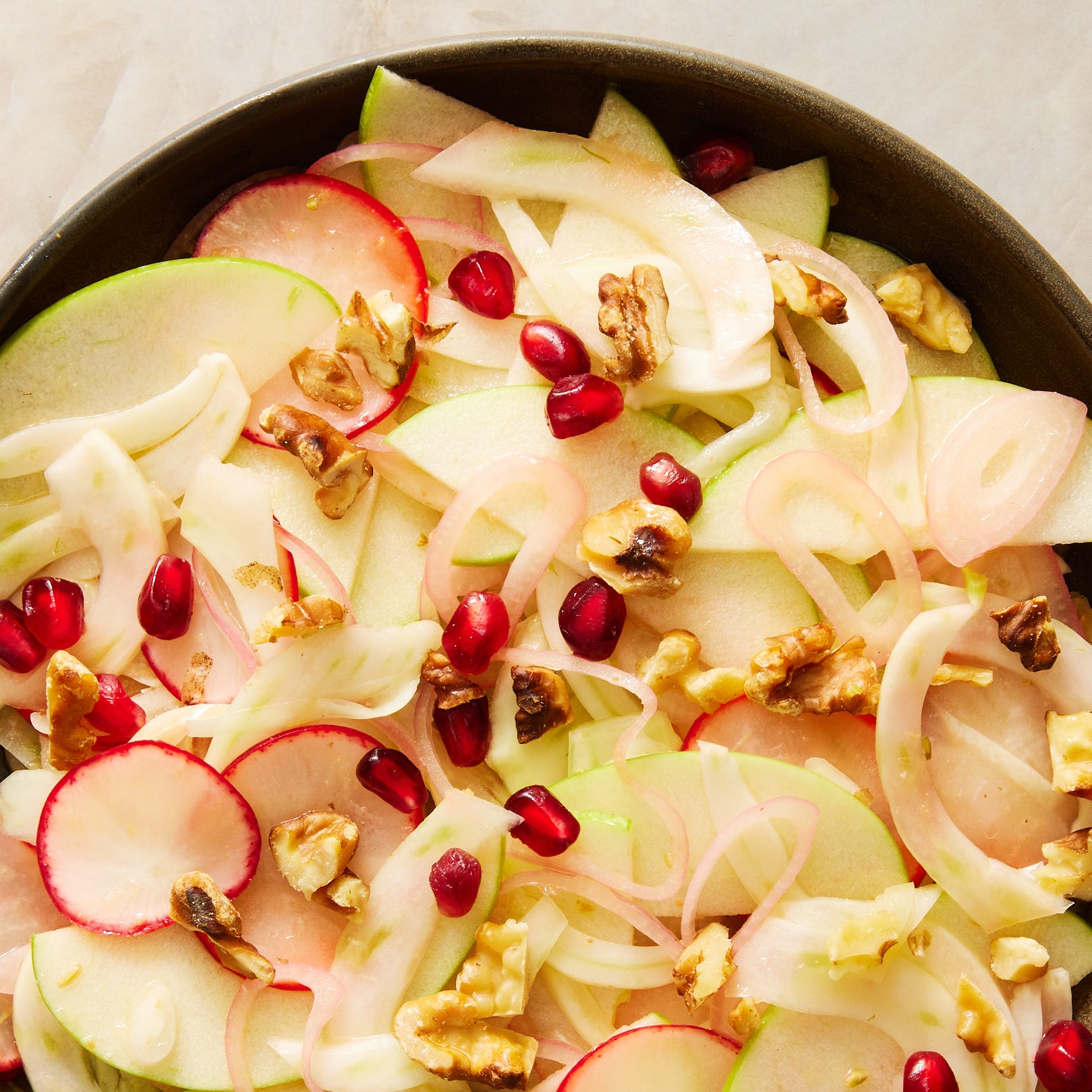 fresh fennel salad with apples, radishes, shallots, pomegranate seeds, and walnuts