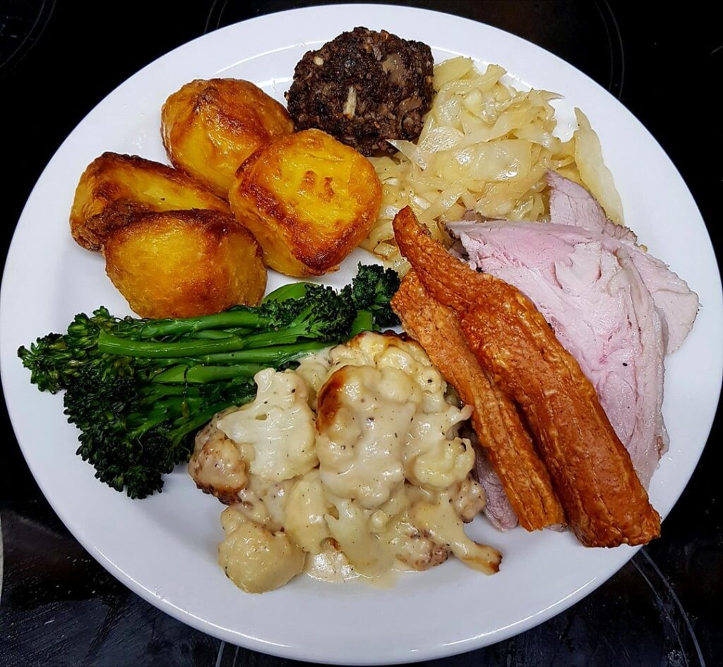 Sunday Roast Pork, Goose Fat Potatoes, Three Cheese Cauli Cheese, Sautéed Broccoli and Cabbage, and Stuffing. Pan and Cider Gravy.
