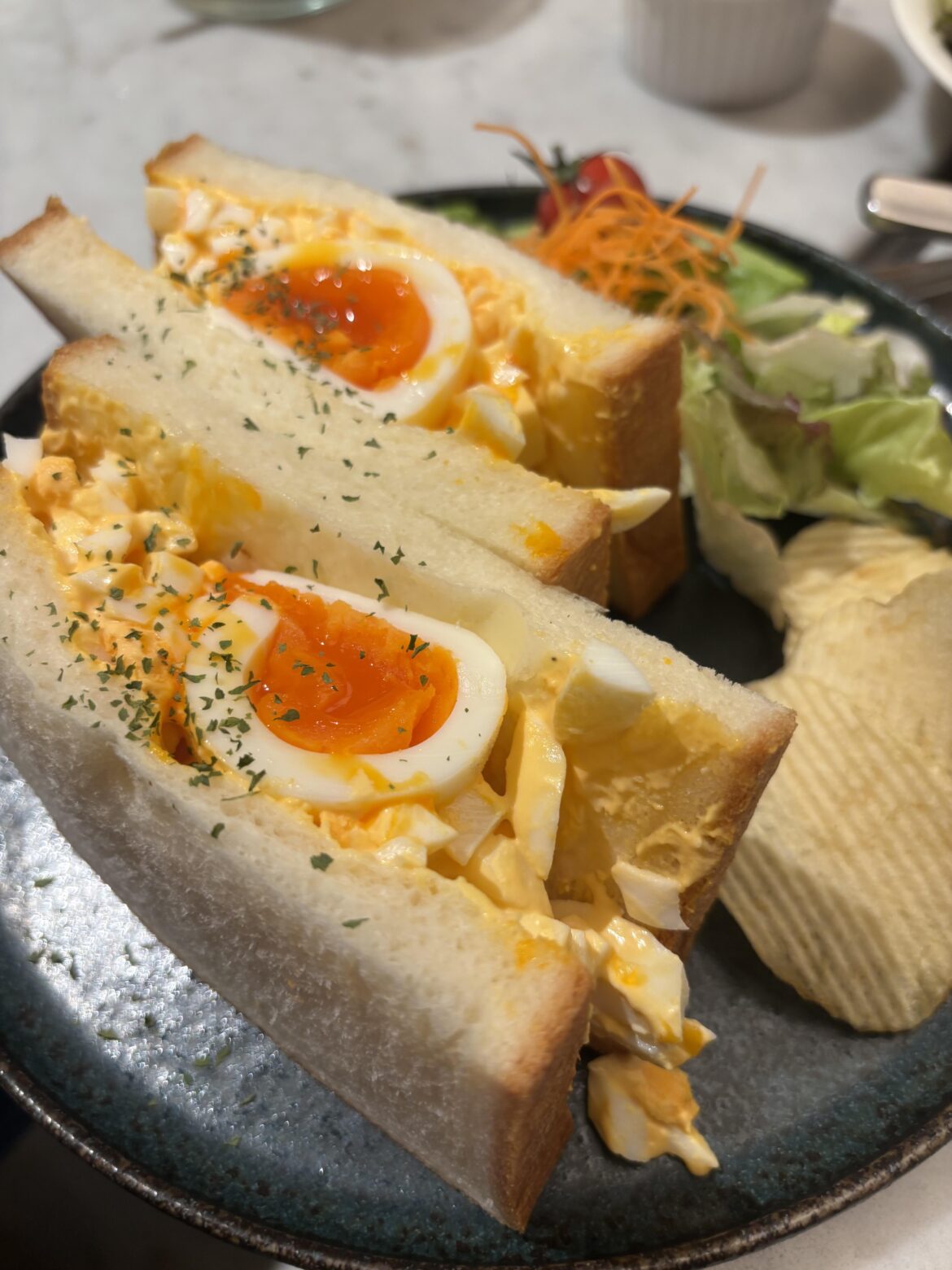 I ate an egg sando with chips and salad at NOA cafe in Tokyo.