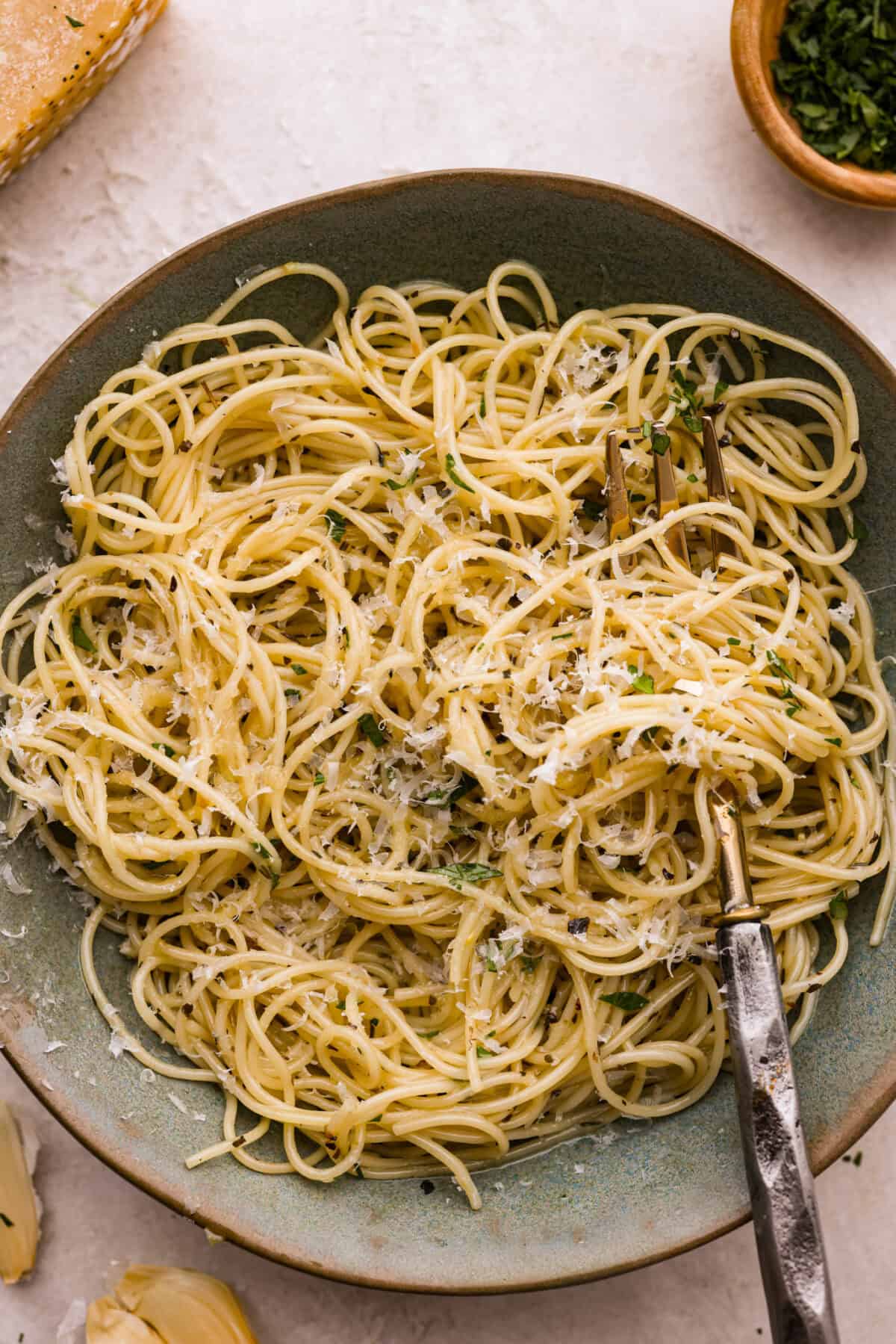 Garlic butter pasta is a quick and simple dish yet packed with flavor. Angel hair pasta is bathed in a buttery garlic sauce and topped with Italian seasoning. Overhead shot of plated garlic butter pasta.