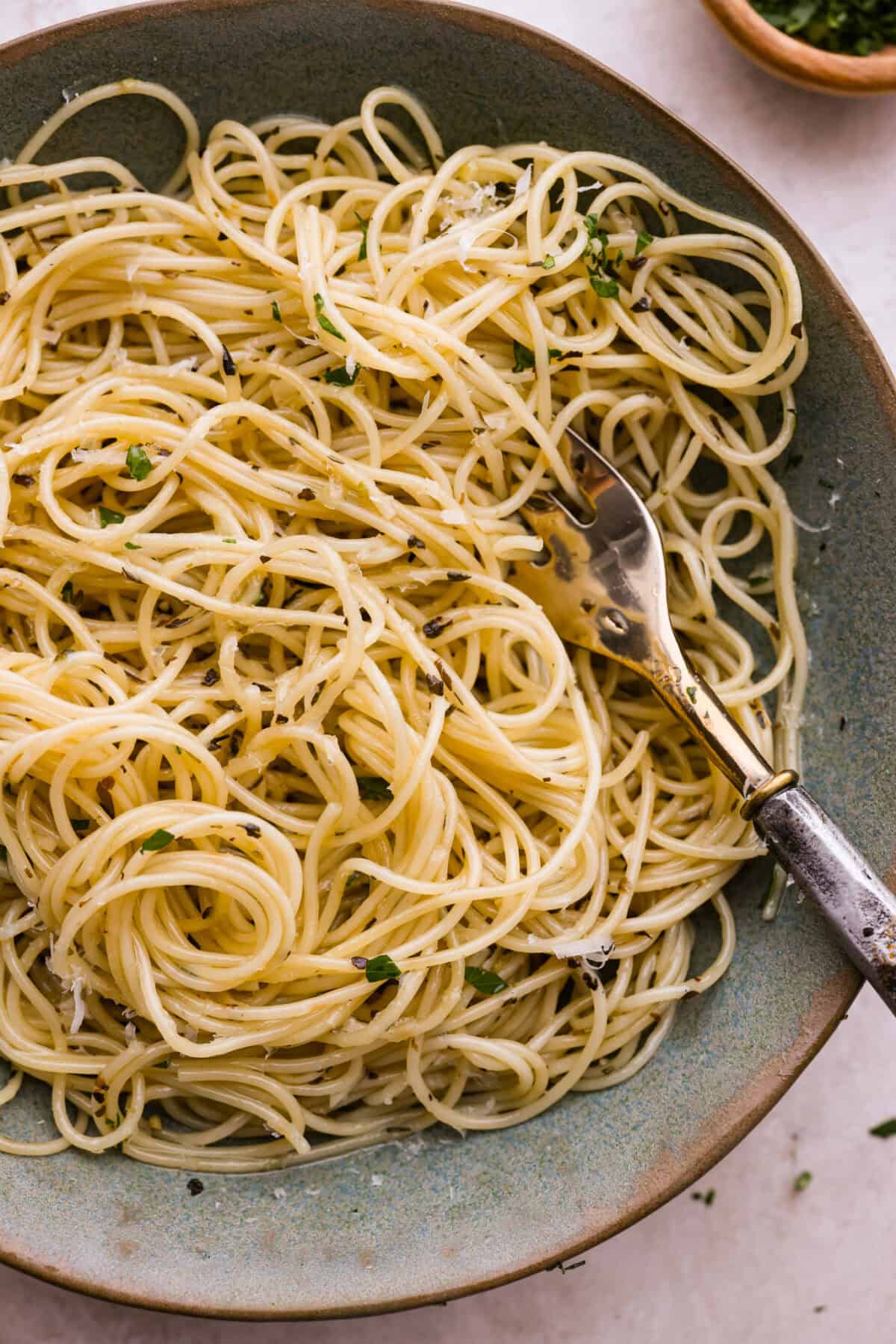 Garlic butter pasta is a quick and simple dish yet packed with flavor. Angel hair pasta is bathed in a buttery garlic sauce and topped with Italian seasoning. Close up shot of plated garlic butter pasta.