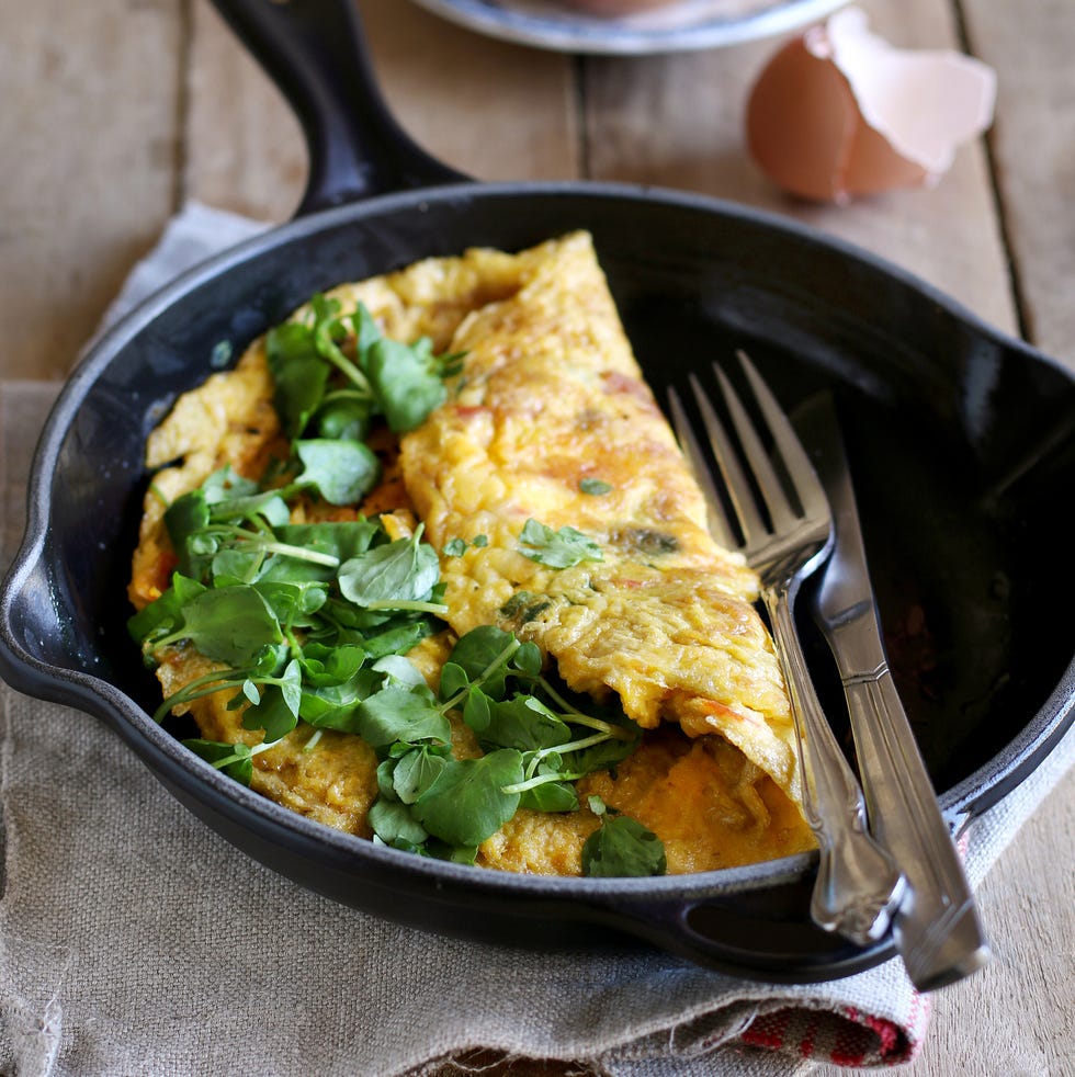 Homemade omelet with watercress on wooden background