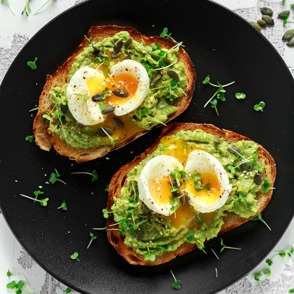 Healthy avocado and egg toasts with pumpkin and sesame seeds, sprinkled with cress salad