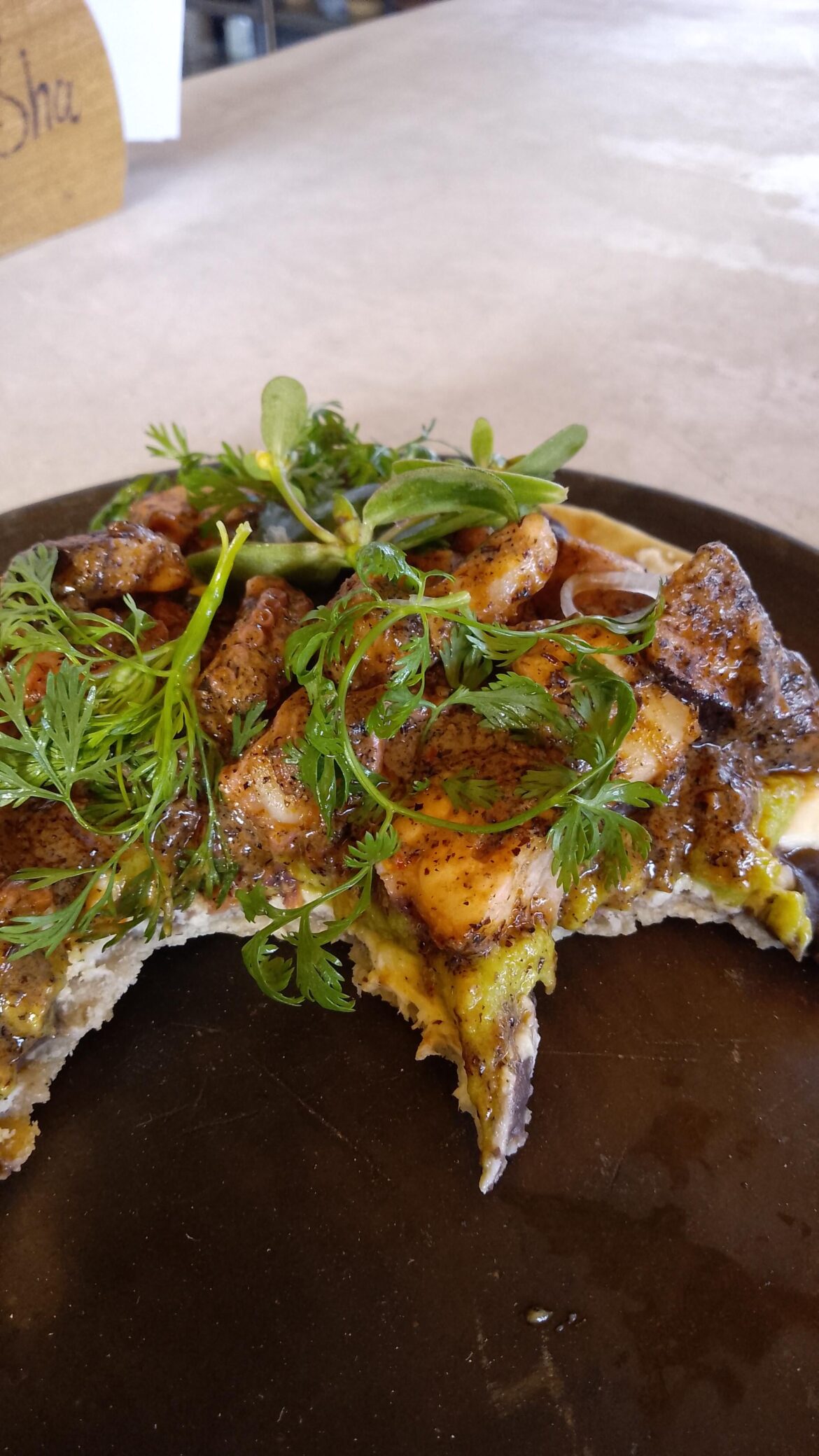 A pulpo tostada with chicatana salsa, quelite AND avocado . Well... A half tostada