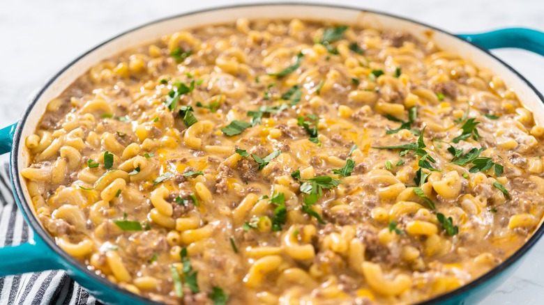 A large skillet of prepared Hamburger Helper, topped with parsley