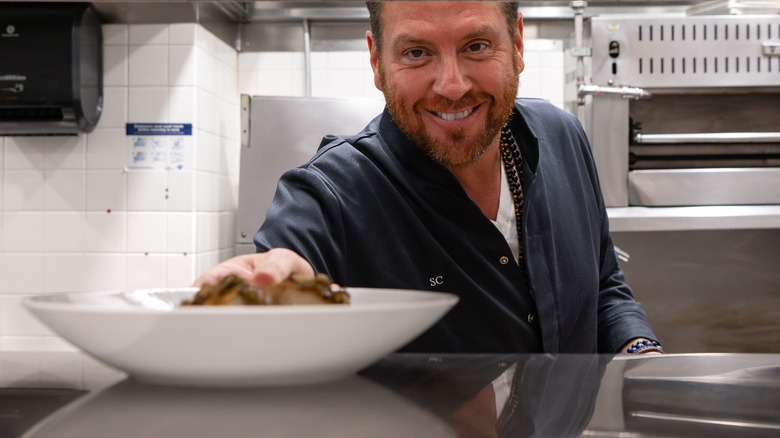 Chef Scott Conant presenting a plate of food