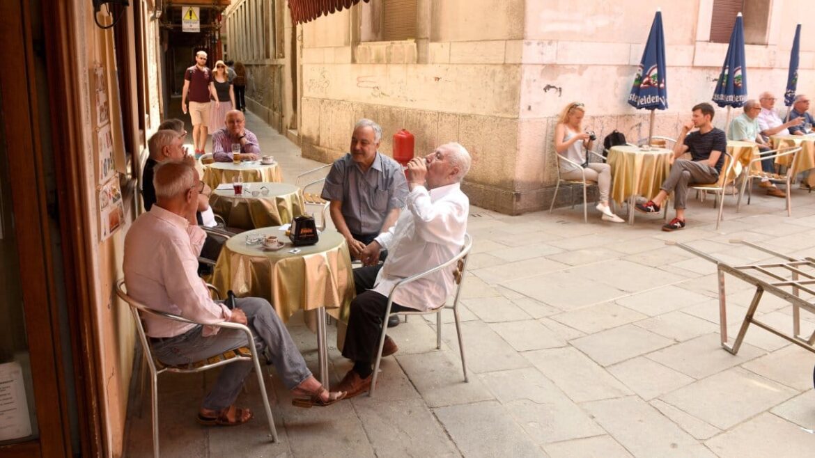 Why do Italians live longer? Diet and lifestyle secrets Italian seniors gather at an outdoor cafe in Venice, highlighting the importance of social interaction for longevity