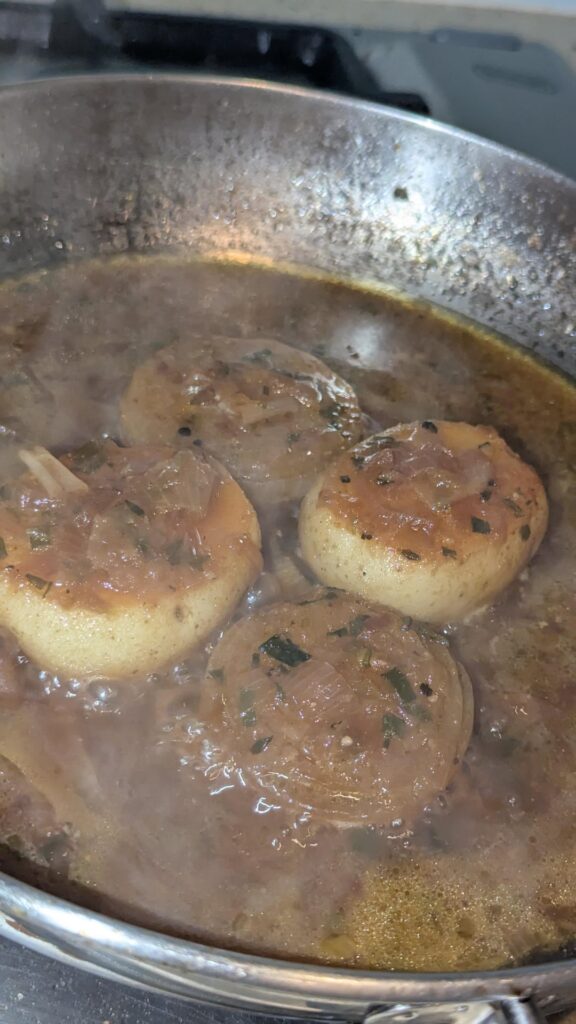 Onions and potatoes cooked slow in the big stainless steel pan.