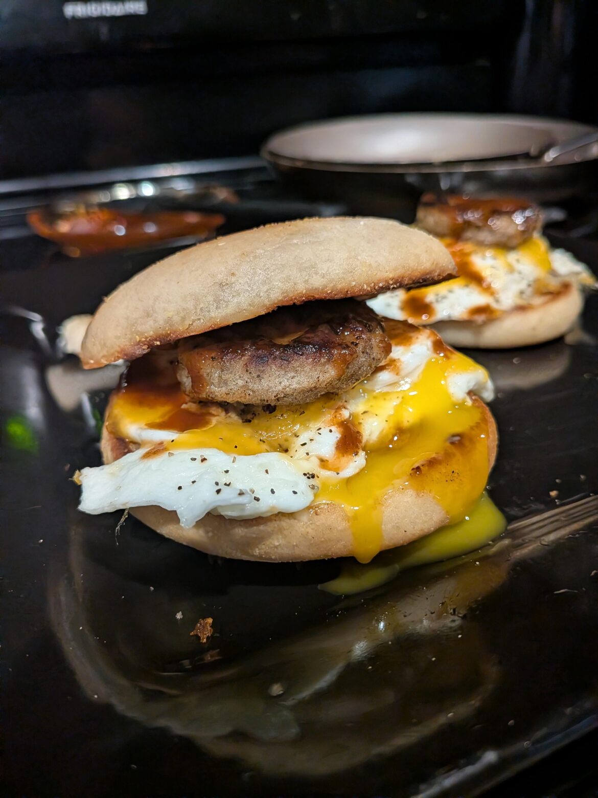 Sausage egg and cheese on a sourdough English muffin with chipotle Cholula sauce