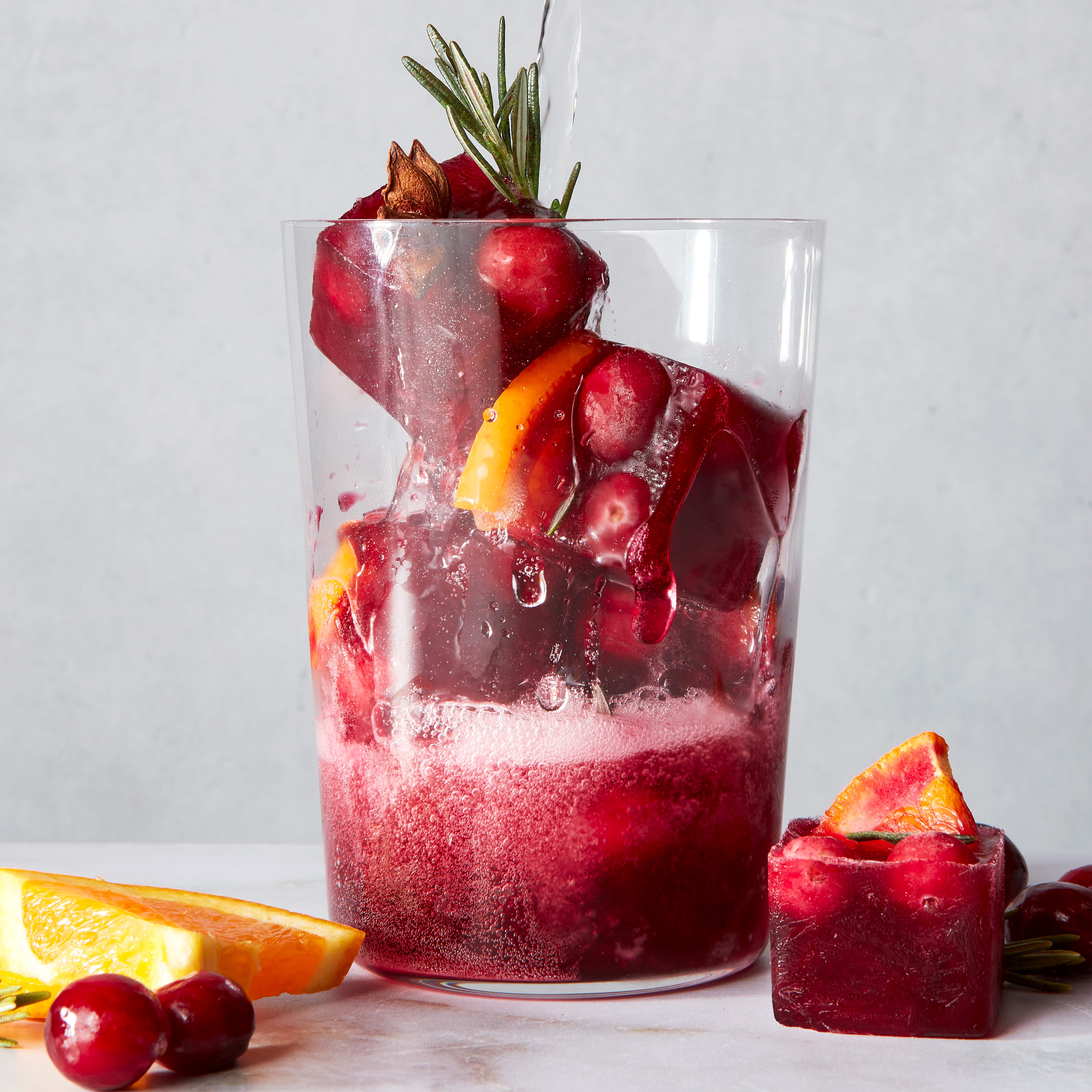 red frozen ice cubes with orange slices and spices