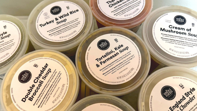 An overhead view of an assortment of Whole Foods prepared soup tubs