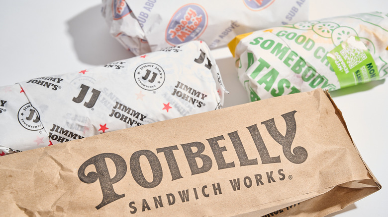 Wrapped sub sandwiches on a white table