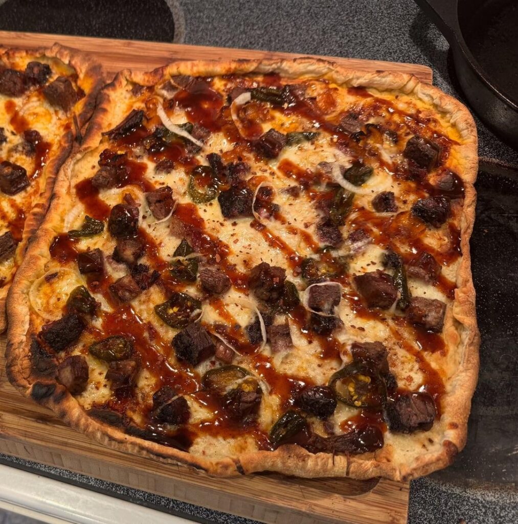 Pizza with brisket leftovers, candied peppers, onion, and mozz/monteray jack mix.