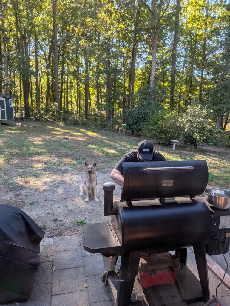 Head chef supervises sous-chef at the smoker