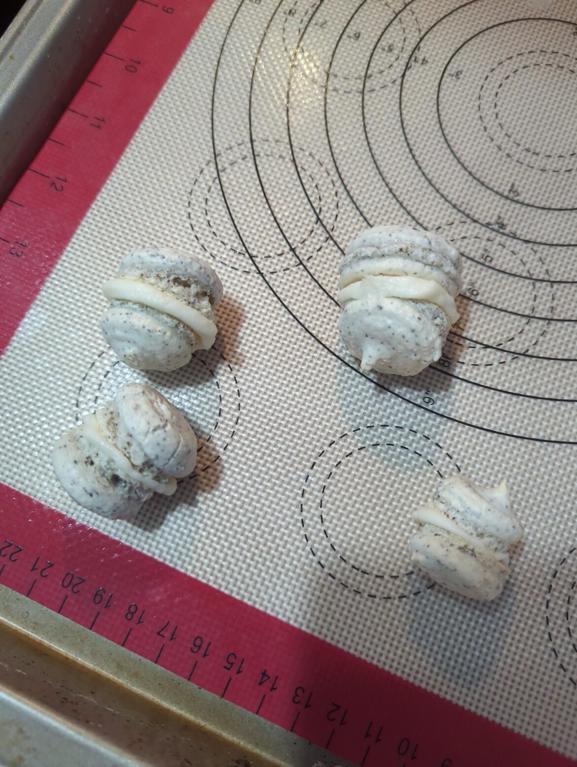 First time making macarons, lot.of things obviously wrong but my main question for when I try again is how to get rid of the "hats" from the meringue coming up when I lift the piping bag?