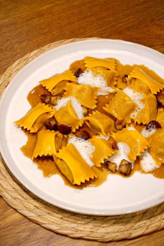 Duck Agnolotti in roasting sauce, with chestnut and Parmesan foam. Duck Agnolotti in roasting sauce, with chestnut and Parmesan foam.