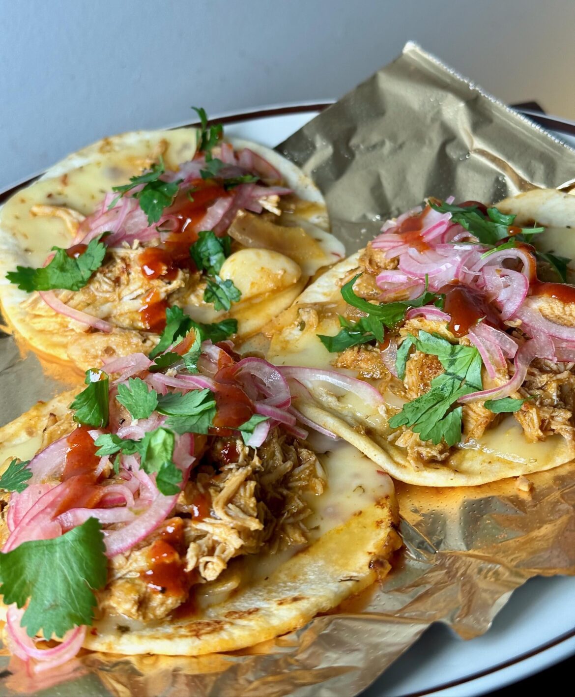 Shredded butter chicken, Pepper Jack, pickled red onions, gochujang, cilantro.