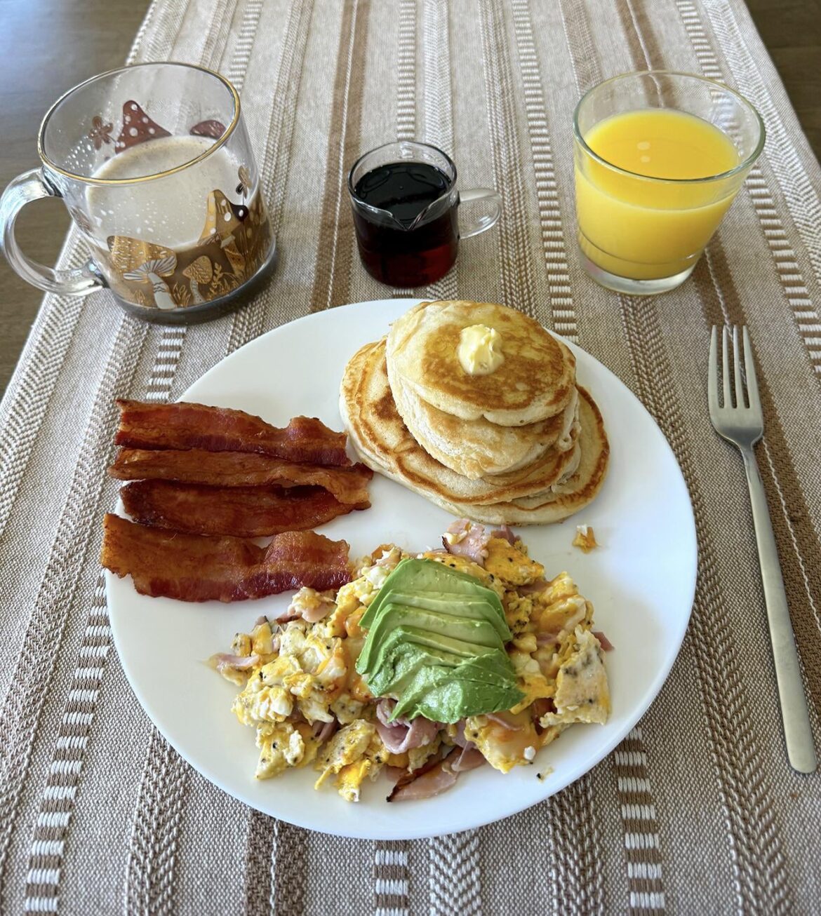 Scrambled eggs with ham, cheese, and avocado. Thick cut bacon and pancakes 🥞