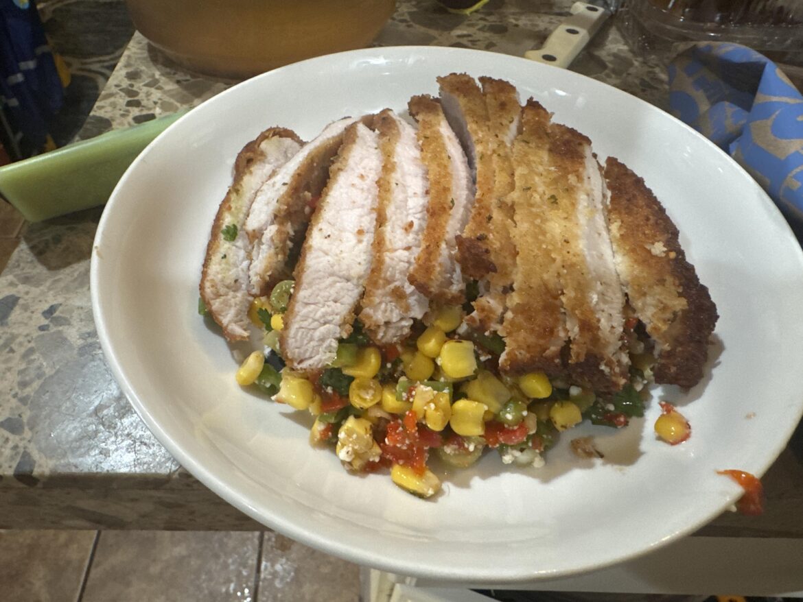 Pork cutlet on a bed of corn 🌽 roasted peppers 🫑 scallions cheese 🧀 and lime vinaigrette.