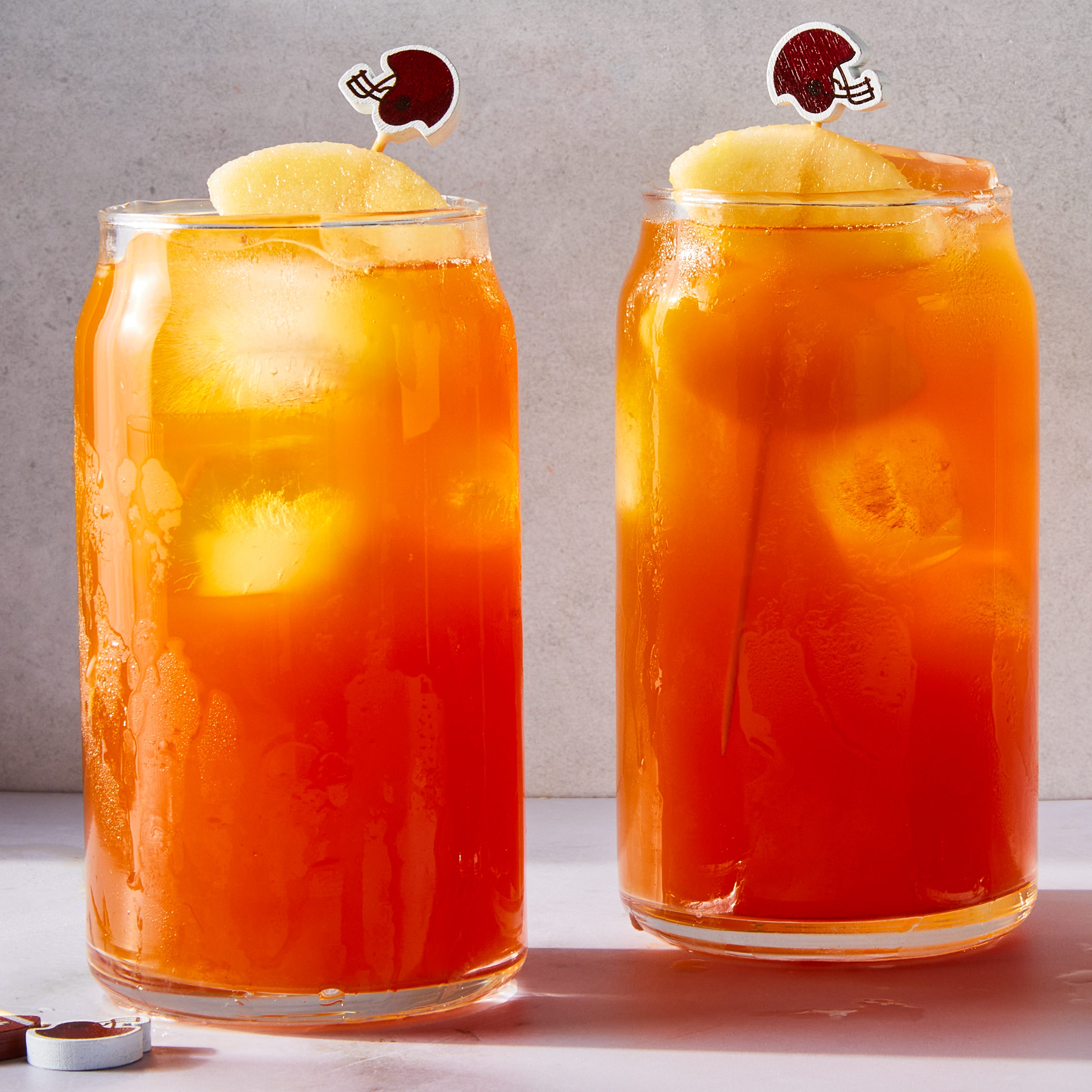tea in a glass with a peach slice and mini football garnish