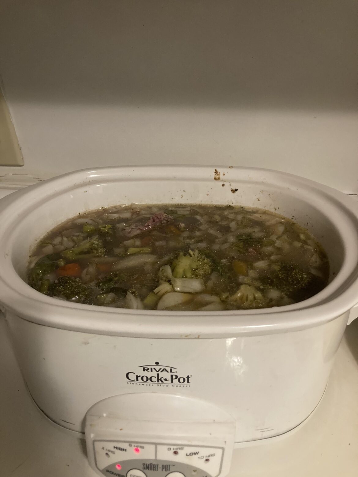 Slow cooking a ribeye steak with tons of veggies and broth