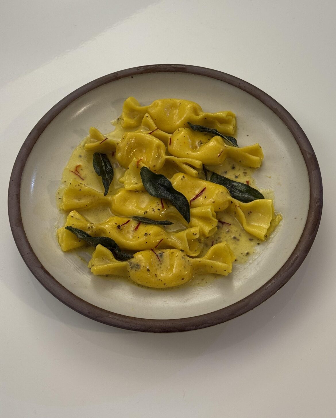 butternut squash and ricotta stuffed caramelle with butter, sage, saffron, and truffle