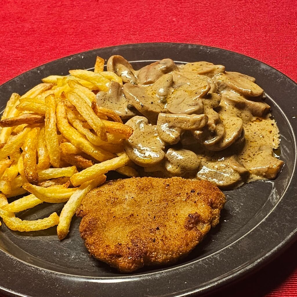 Jägerschnitzel (hunter's schnitzel) with a creamy Madagascar-style mushroom sauce, and air-fried fries made from floury potatoes