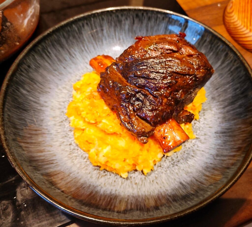 Beef short rib with red wine gravy, carrot and parsnip mash, baked potato and chive mash