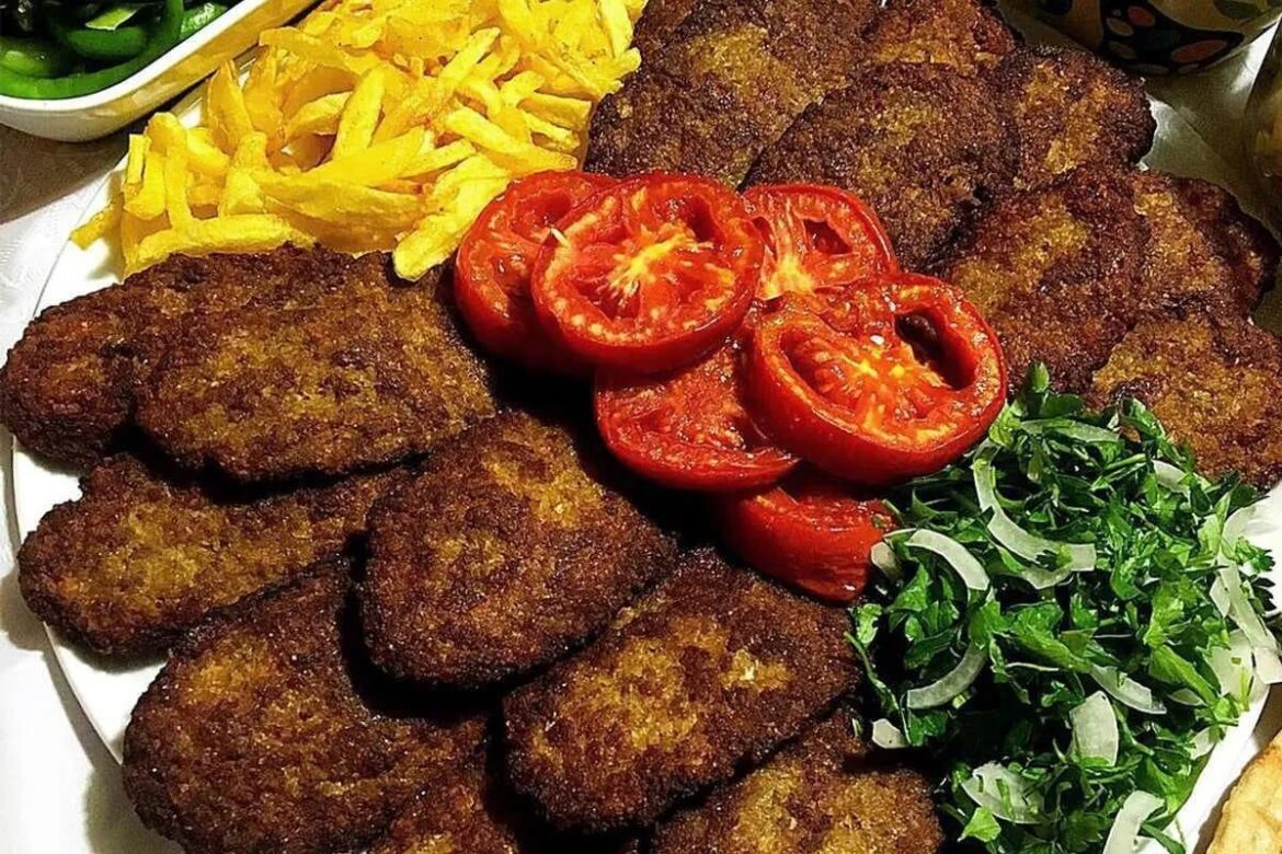 Persian Kotlet [OC]  Golden crispy meat and potato patties from Iran, served with fresh herbs and pickles