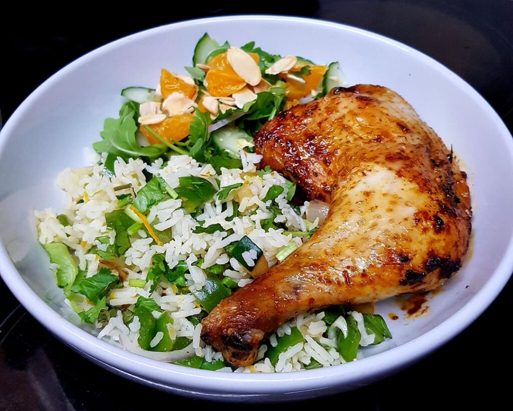 Harissa Roast Chicken, Spicy Vegetable Rice with Orange Zest, and Orange and Rocket Salad. Finished with Herbs and Toasted Almonds.