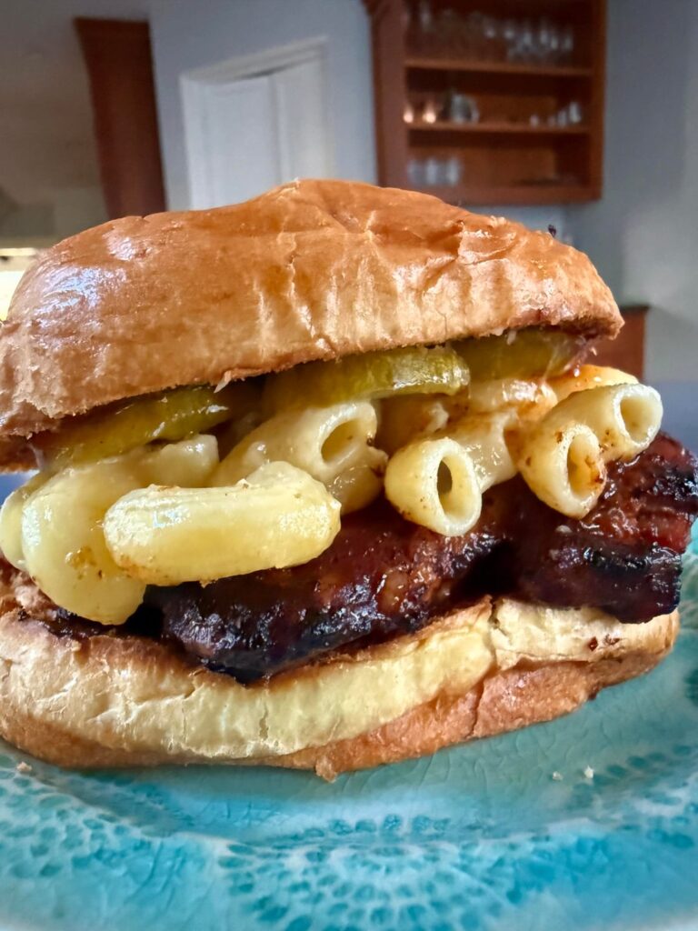 Bbq chicken thigh sandwich with pickles and Mac n cheese
