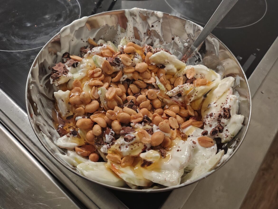 Apple and vanilla skyr salad with dark chocolate, salted peanuts and caramel syrup