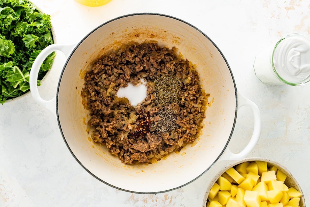 Cooked sausage with spices in a large pot.