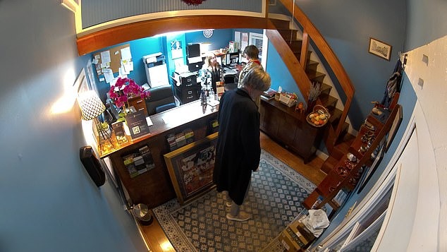 CCTV footage of Natali Ray speaking to a receptionist in a restaurant.