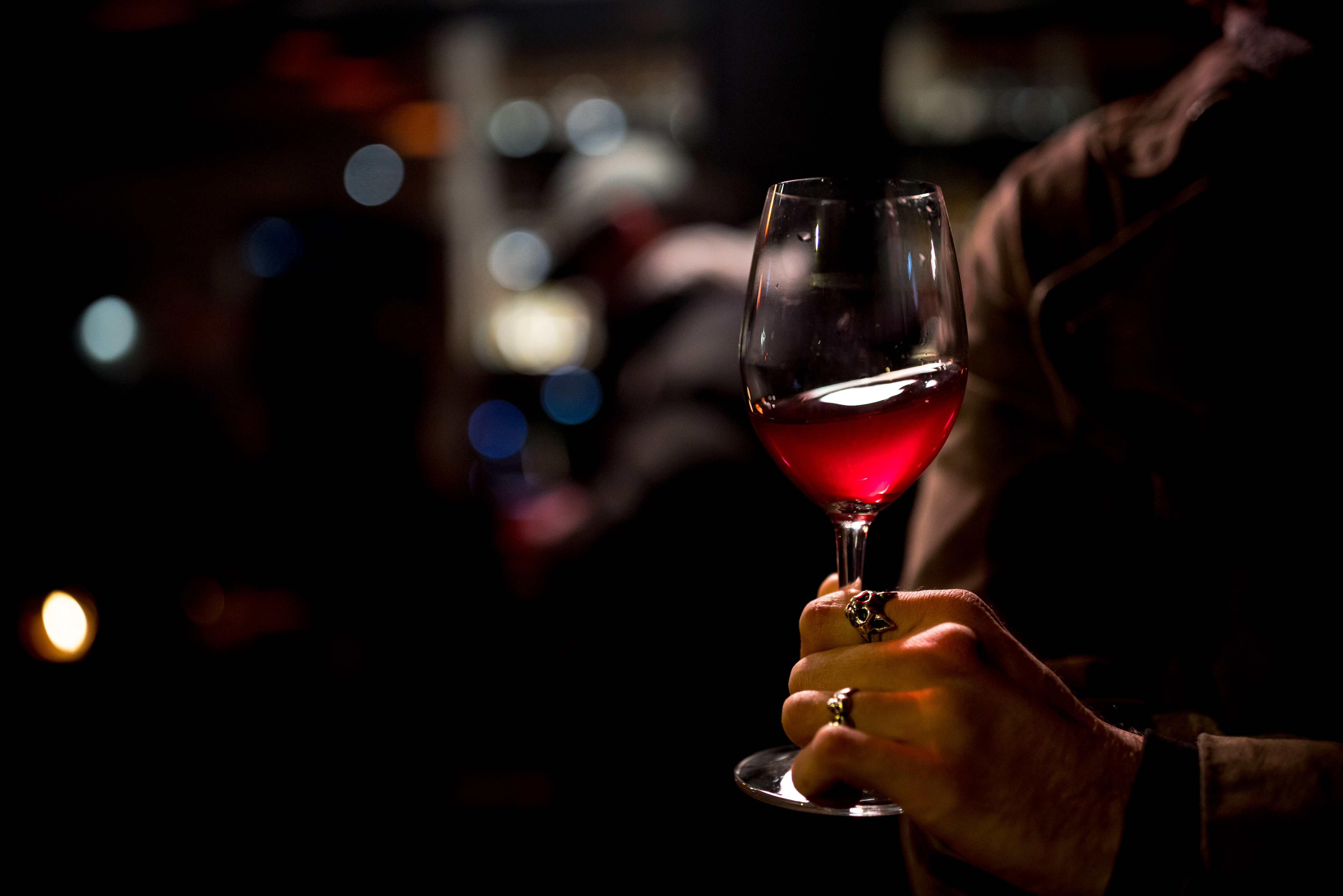 Hand of wine merchant Nathan holding a glass of Obora Sune Beaujolais Nouveau.