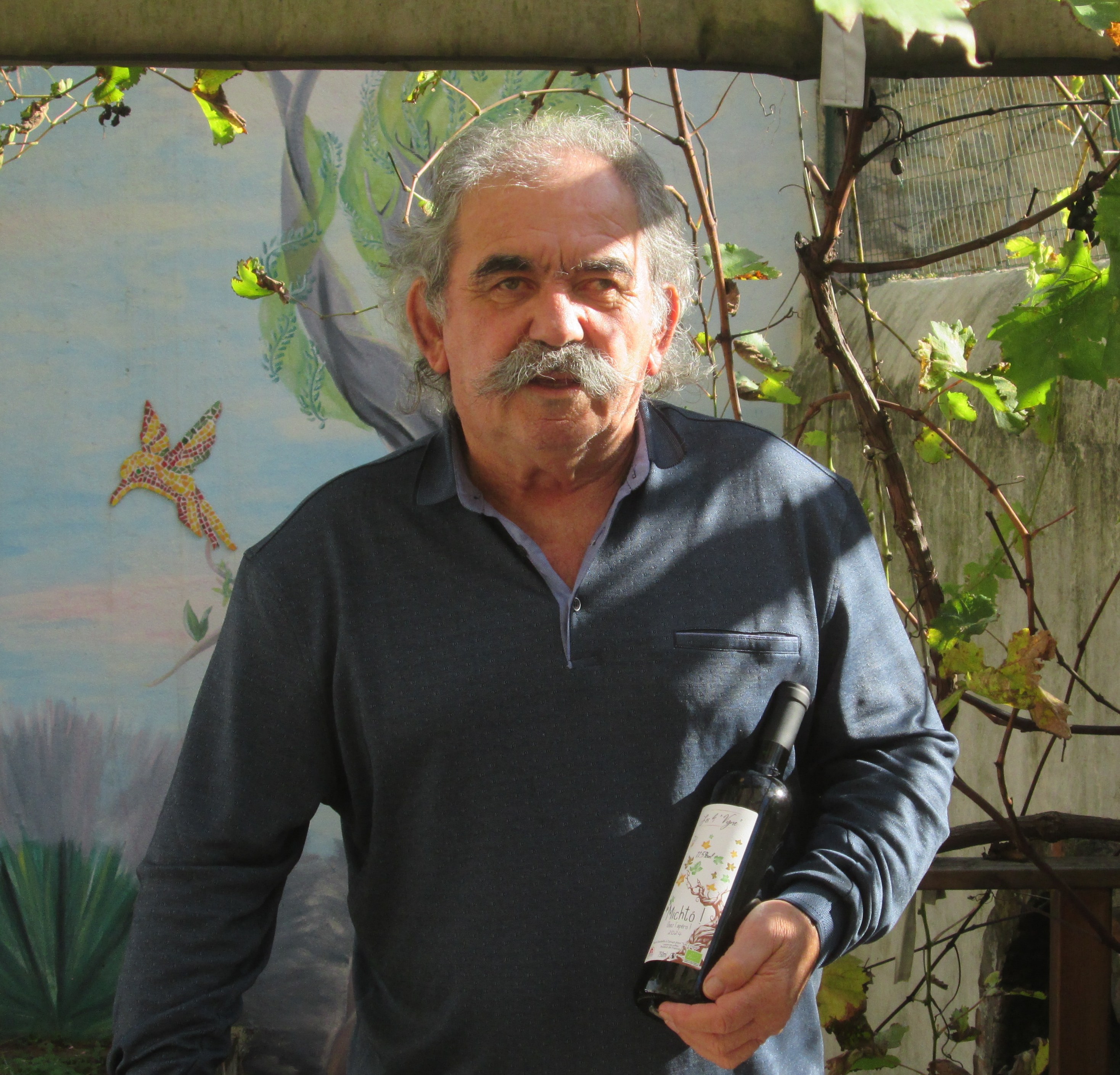 Christian Vigne holding a bottle of wine.